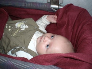 Baby liegt im Flugzeug im Baby Bett