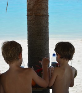 Kinder trinken Kokosnüsse am Strand